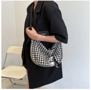 Detail of checkered crescent bag with adjustable strap and mini sneaker charm