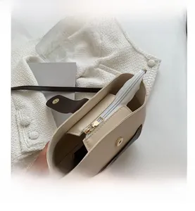 Detail view of smooth zipper closure and premium hardware on bicolor bucket bag
