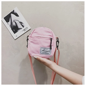 Detailed view of pink canvas crossbody bag with front zipper pocket and strap