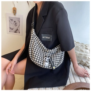 Detail of checkered houndstooth crossbody bag with branded sneaker pendant and wide strap