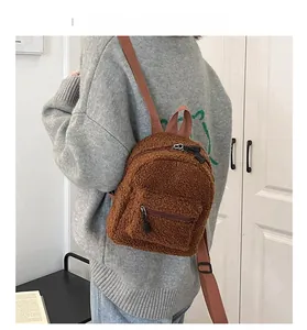 Rear view of a person wearing a brown sherpa mini backpack with plush texture and zip pocket