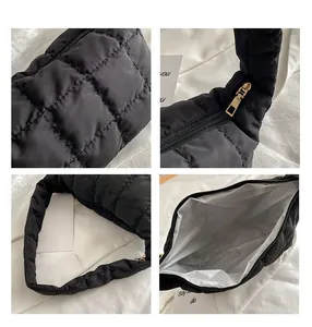 Detail view of black quilted shoulder bag featuring gold zipper and puffy nylon texture