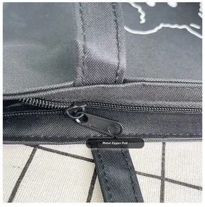 Detail of the high-quality metal zipper and stitching on this black canvas tote bag