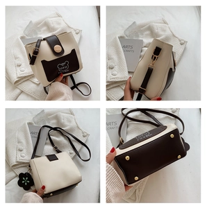 Detail view of contrast bucket bag with cartoon bear print, floral charm and bottom studs