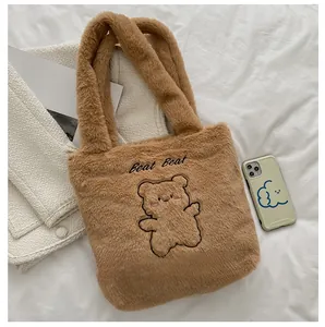 Gros plan du sac fourre-tout en peluche marron avec broderie ours et texture douce