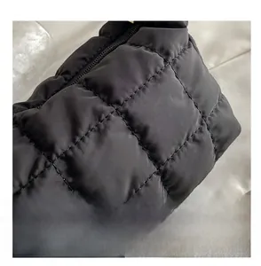 Close-up of black quilted shoulder bag featuring square stitching and nylon texture