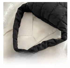Detail shot of the comfortable padded shoulder strap on a black quilted nylon crossbody bag