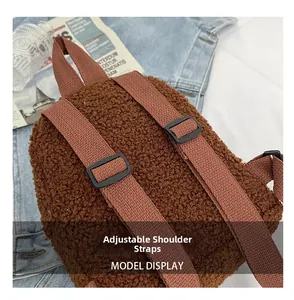 Detail view of adjustable fabric straps on a brown teddy fleece mini backpack