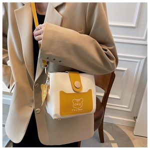 Detailed close-up of a two-tone yellow bucket bag featuring a cute cartoon bear print
