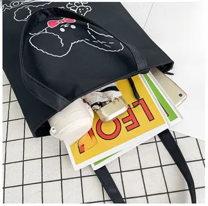 Detailed top view of a black canvas tote bag showcasing high capacity with daily essentials