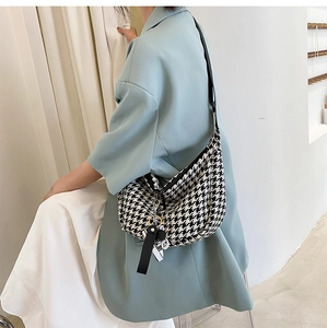Detail of checkered crossbody bag with adjustable strap on model back view