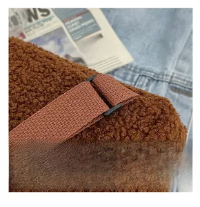 Detail of adjustable black metal buckle and brown plush lambskin fabric on strap