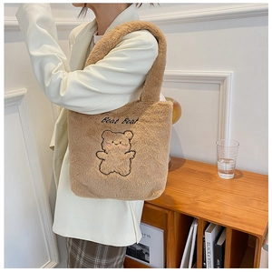 Détail du cabas en peluche marron avec broderie ours et texte sur la texture