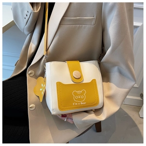Detail of a mini bucket bag featuring a yellow bear print and wooden decorative button