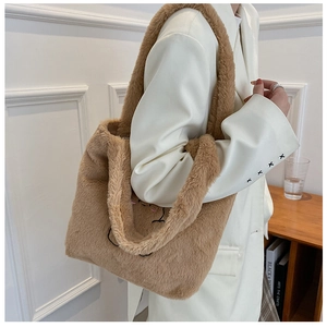 Détail d'un sac cabas en peluche marron avec broderie minimaliste de visage d'ours