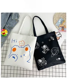 Detail of canvas tote bags with cartoon bear and space graphics on checkered fabric
