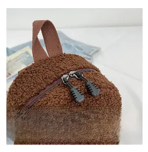 Macro view of brown teddy fleece backpack with top handle and dual smooth zippers