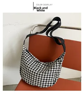 Detail of black and white houndstooth crossbody bag with adjustable wide strap