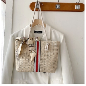 Detail of handwoven tote bag with striped ribbon, cotton rope handles and silk scarf accent
