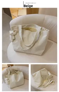 Detail view of beige corduroy tote bag showing ribbed texture and cute bear pendant