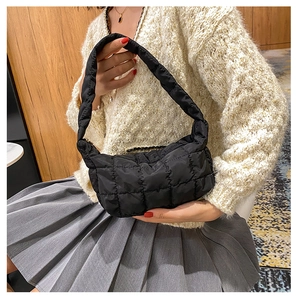 Detail of black quilted puffer bag with chic lattice stitching and nylon texture