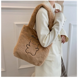Gros plan sur le fourre-tout en peluche marron avec broderie d'ours et texture douce