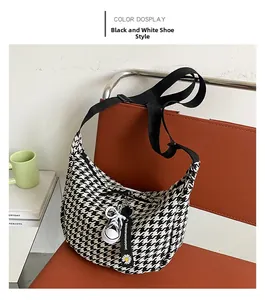 Detail of checkered canvas crossbody bag with mini sneaker charm on a leather seat