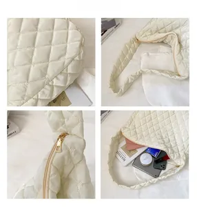 Detail view of quilted puffer tote bag featuring gold zipper and spacious inner capacity