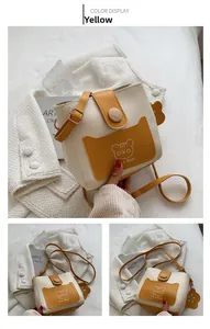 Detail of color-block mini bucket bag with cartoon bear and elegant wooden buckle closure