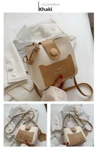 Detail view of khaki bucket bag with wood buckle closure and cute bear print