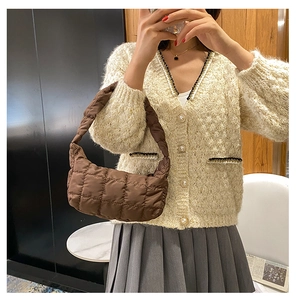 Detailed view of a brown quilted shoulder bag with soft nylon texture and crescent shape