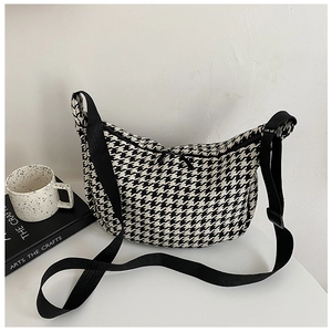 Detail of classic houndstooth crossbody bag with adjustable strap and metal zipper
