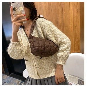 On-body view of a brown quilted shoulder bag featuring a padded puffy texture