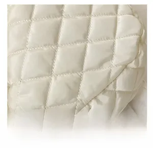 Close-up of beige quilted nylon bag showing diamond stitching and silky fabric texture