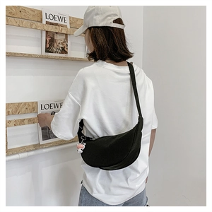 Detail of black crescent crossbody bag with cow pattern and wide adjustable shoulder strap