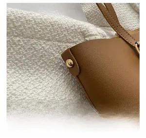 Close-up of golden rivet hardware on soft caramel leather tote bag detail