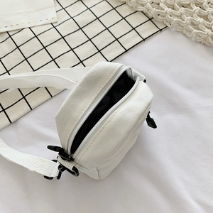 Mini white canvas crossbody bag with black zipper detail and adjustable strap