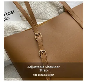 Close-up of adjustable brown leather strap with gold buckle on a large tote bag
