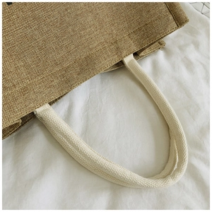 Detailed close-up of natural jute fabric texture and durable cotton rope handle