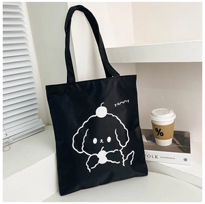 Detail of black canvas tote bag with white cartoon dog print and coffee cup on white sill