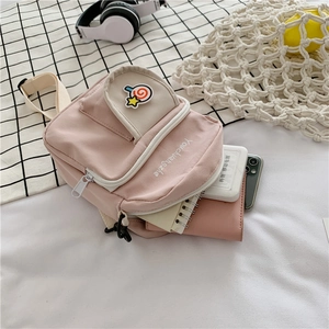 Pink canvas mini crossbody bag with lollipop embroidery showing interior storage capacity