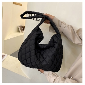 Detail view of black quilted cloud shoulder bag with spacious interior and soft nylon fabric