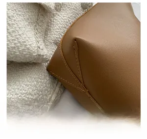 Close-up of brown leather tote bag corner showing fine stitching and textured finish