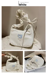 Detailed view of white nylon shoulder bag with heart whale patch and ruffled strap