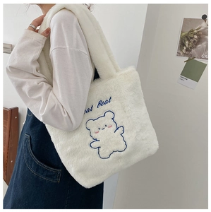 Détail du sac cabas en fausse fourrure blanche avec broderie ours et bandoulière peluche