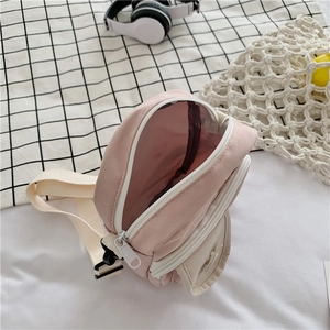 Detail of a pink canvas crossbody bag with double zippers and inner storage space