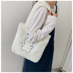 Détail de la texture pelucheuse du sac cabas blanc avec broderie d'ours bleu doux