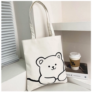 Detail of white canvas tote bag featuring a minimalist black line cartoon bear print