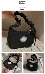 Detail of black canvas bag featuring a heart-shaped whale patch and ribbon bow