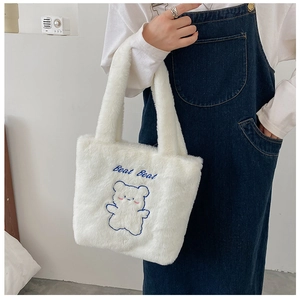 Détail du sac cabas en peluche blanche avec broderie d'ours bleu et poignées douces